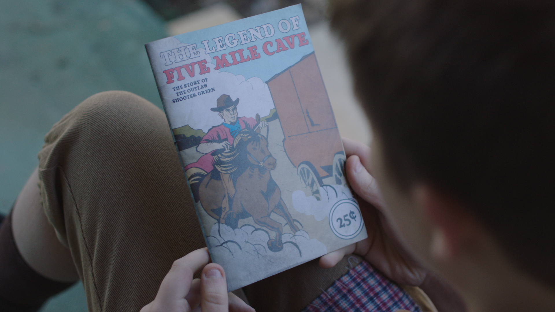 Tommy holding The Legend of 5 Mile Cave 